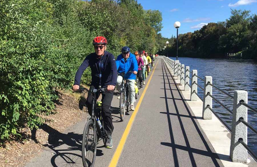 A group is cycling on Rideau Canal enjoying Escape Ottawa bike tour