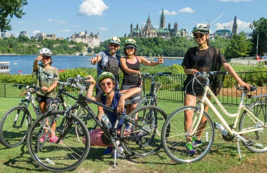 A family is enjoying an Ottawa tour by bike visiting landmarks with Escape Tours and Rentals