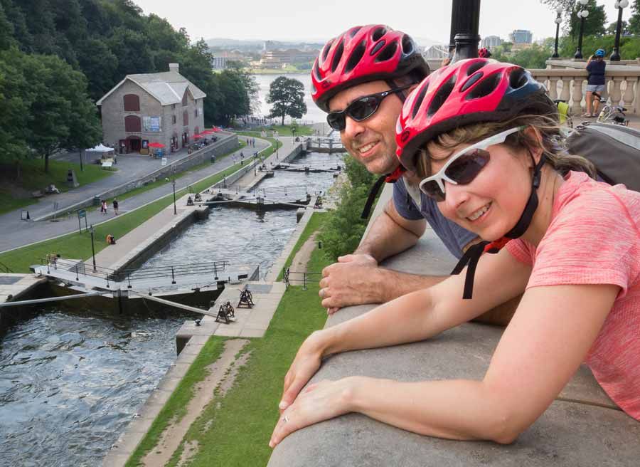A couple watching Rideau Canal locks from Fairmont Chateau Laurier look out during Ottawa bike & boat tour by Escape