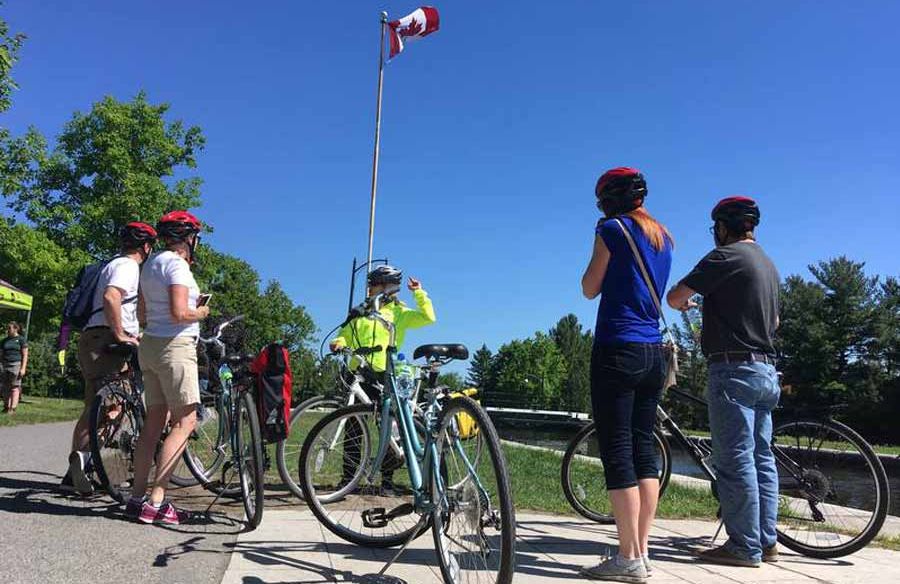 Tour guide showing participants an Ottawa landmark during Ottawa multi-day cycling tour by Escape tours on Sparks