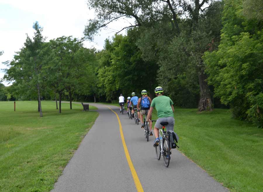 Group is cycling on safe Rideau River bike trail during private best of Ottawa day tour by bike by Escape on Sparks