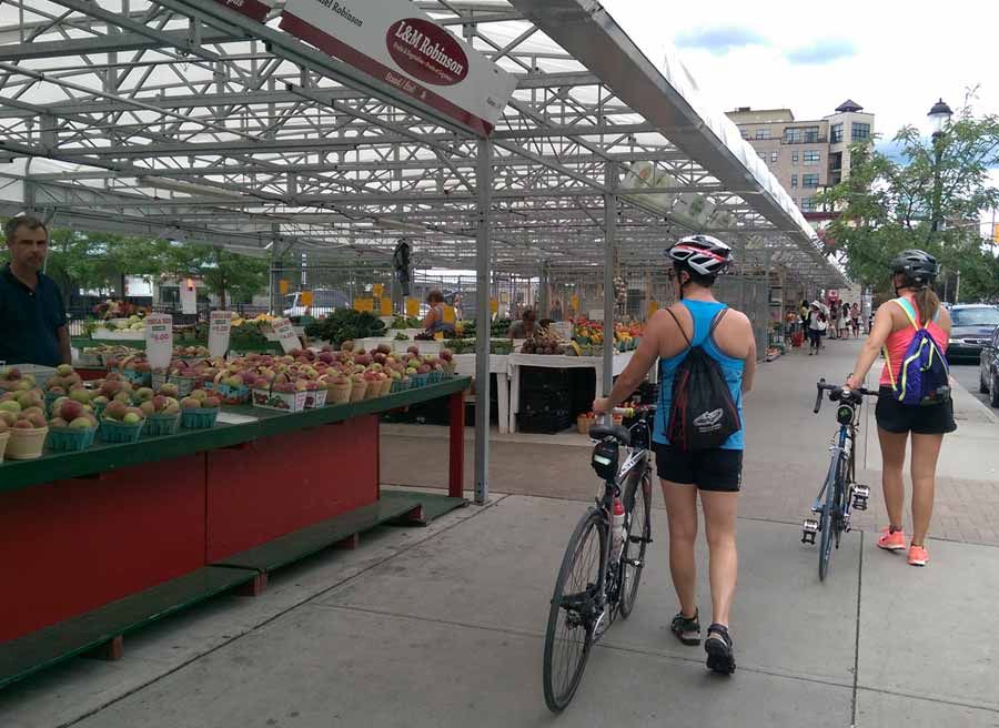 Guest are biking through Ottawa farmers’ market during best of Ottawa Neighbourhood and nature bike tour with Escape