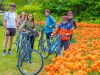 Tulip bike tour guests taking a group picture in front of orange tulips during Tulip festival at Commissioners park in May