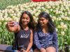 Friends are taking selfie in front of a tulip flower garden during Escape garden bike tour in Ottawa at Dow’s Lake