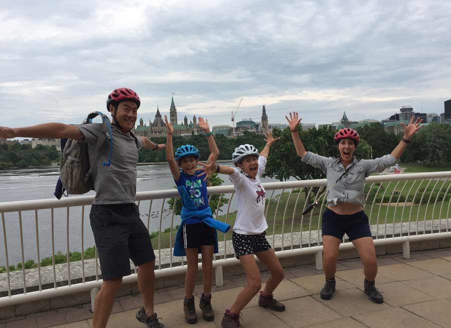 Family is happy at the Museum of History lookout at with a view of Parliament building on an Ottawa express bike tour 