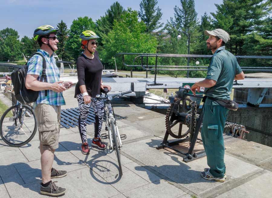 Tour participant chat with Lockmaster at Rideau Canal lock close to experiential farm during best of Ottawa bike tour by escape