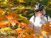 A guest smiling & taking a picture with Fall colours in Ottawa park during Ottawa multi-day cycling tour by Escape on Sparks