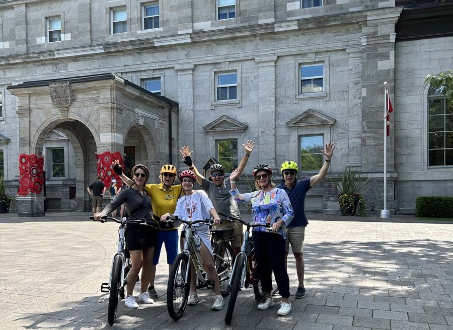 A family has joined Ottawa Electric Bike Tour with Escape in Ottawa and are taking a picture with Escape Guide at Rideau Hall