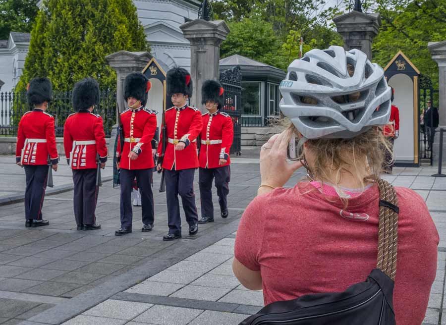 A guest is watching and taking a picture of the change of guard ceremony at Rideau Hall during best of Ottawa bike tour 