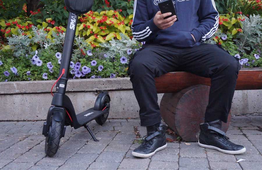 A man has rented an electric scooter from Escape rentals on sparks and is enjoying his rental e scooter in a park in Ottawa.