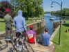 Participants sitting at a bench watching boats crossing Hartwells lock at Rideau Canal during best Ottawa bike tour by Escape