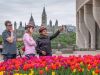 A family is taking a picture at the museum of History lookout with a the parliament view during their private Best of Ottawa bike tour with Escape