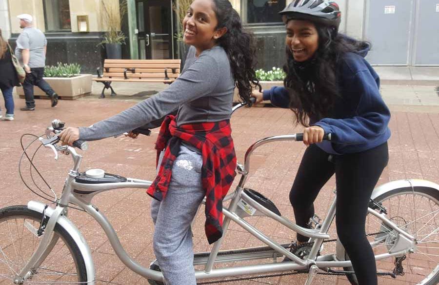 Friends laughing while riding a 2-person bike with Escape tandem bike rental on Sparks St., Ottawa