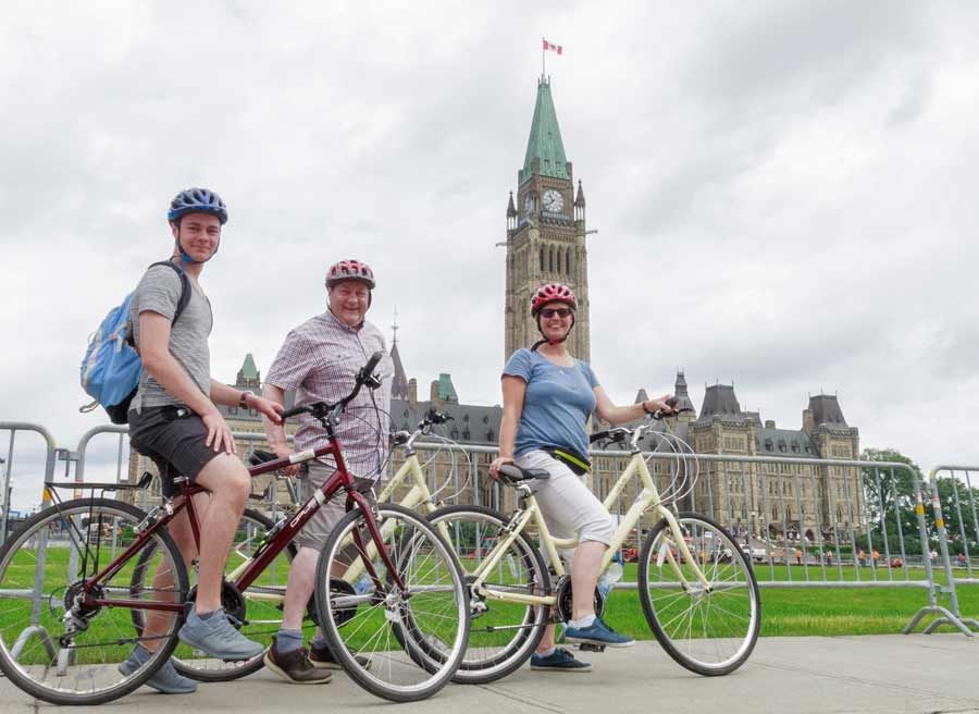 A family visits Parliament Hill and Peace Tower landmarks during best Ottawa bike tour in one day by Escape on Sparks