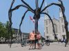 A couple has joined a private Ottawa Electric Bike tour with Escape in Ottawa and have stopped at Maman status for taking pictures and for sightseeing