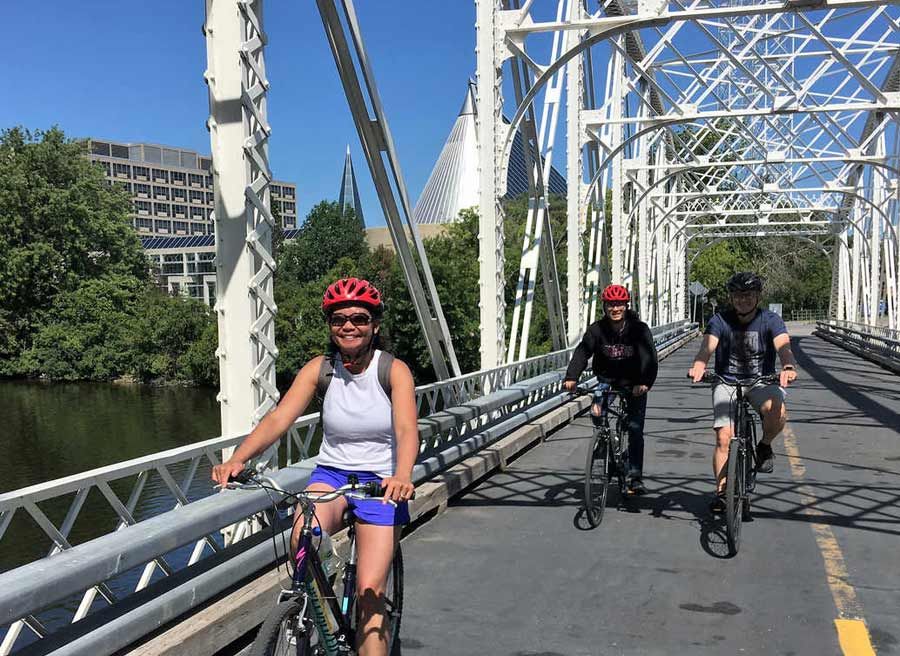 Tour participants are cycling on Minto bridge in new Edinburgh neighbourhood during Escape Ottawa express bike tour
