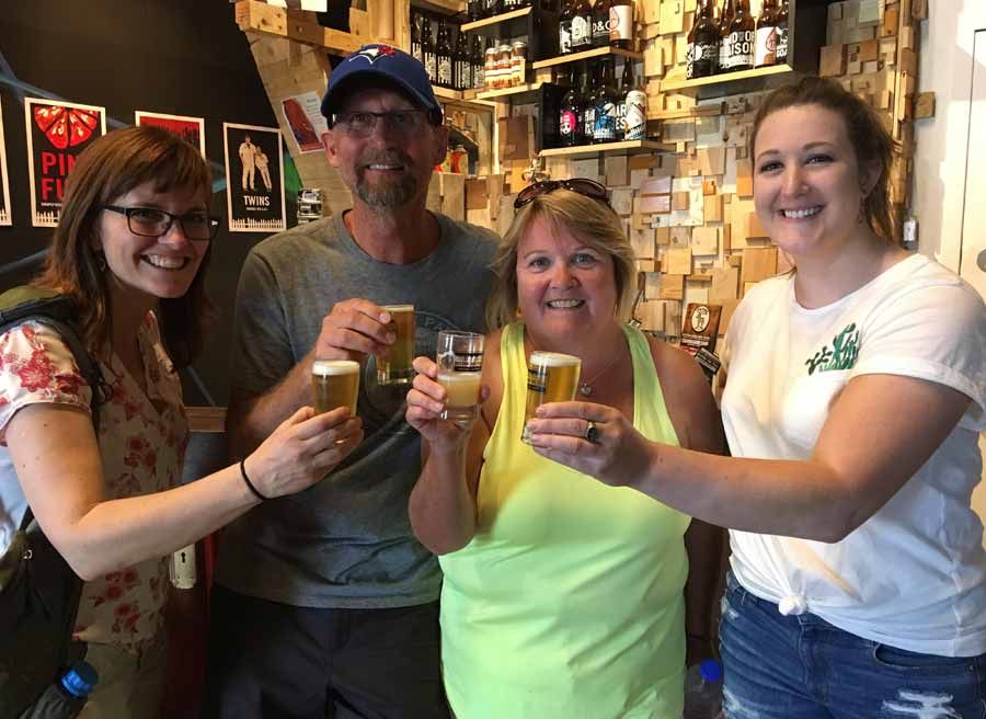 A couple and guide drinking craft beer at Beyond Pale microbrewery during their private bike and food tour of Ottawa 