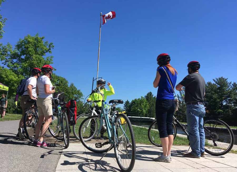 Tour guide showing participants an Ottawa landmark during Ottawa multi-day cycling tour by Escape tours on Sparks