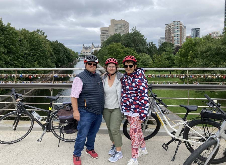 A group is enjoying a stop at Corktown Bridge on Rideau Canal during their Ottawa Electric Bike Tour with Escape.