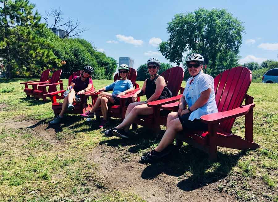 Friends sitting on adirondack chairs looking at Ottawa River during bike & spa tour in ottawa with Escape tours and rentals 