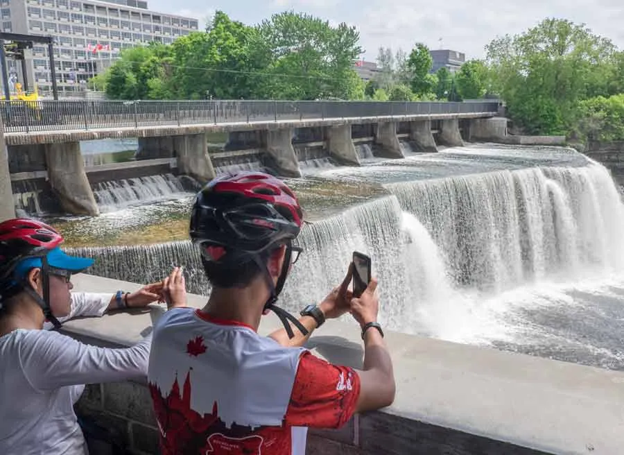 Guests are looking at Rideau falls during their bike and spa tour in Ottawa with Escape tours and rentals on Sparks
