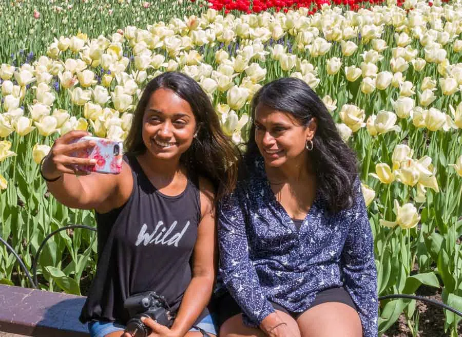 Friends are taking selfie in front of a tulip flower garden during Escape garden bike tour in Ottawa at Dow’s Lake