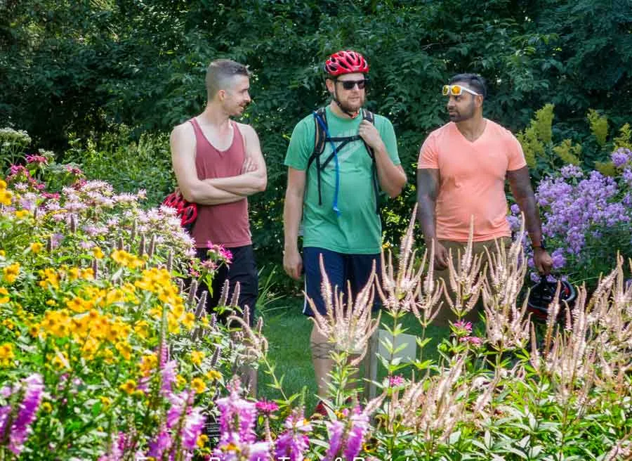 Friends are walking through Fletcher WildLife Garden during Escape garden promenade self-guided bike tour in Ottawa