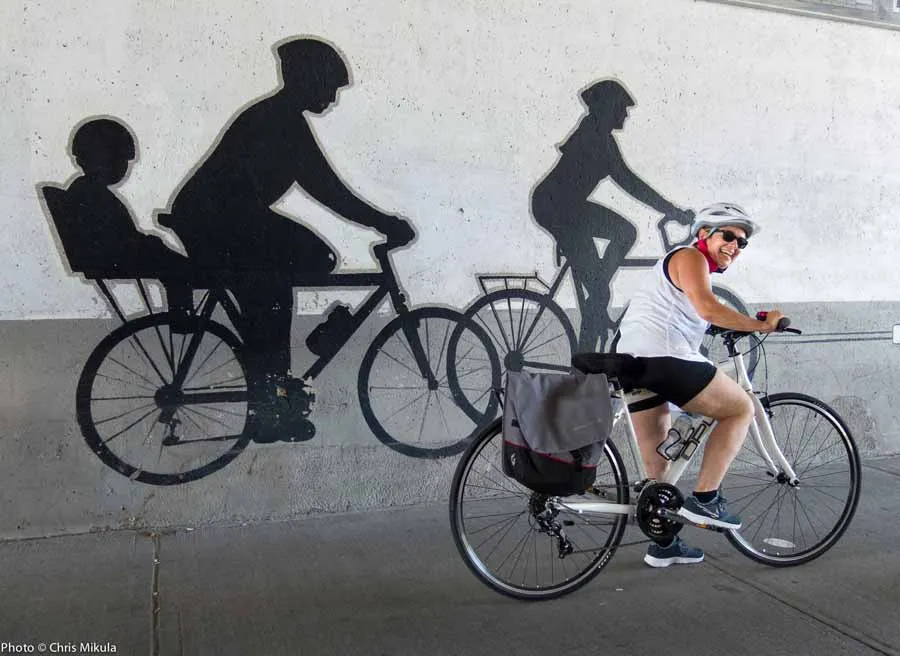 A guest is looking at biking street art mural in Little Italy during during best of Ottawa Neighbourhood and nature bike tour