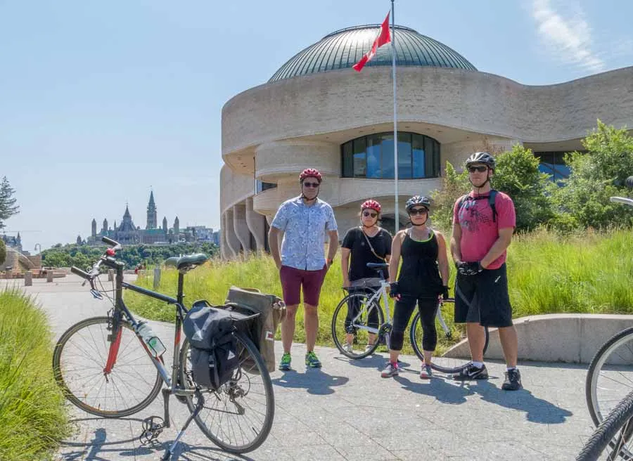 Tour participants taking a picture at History Museum lookout with Parliament view during Ottawa multi-day bike tour by Escape