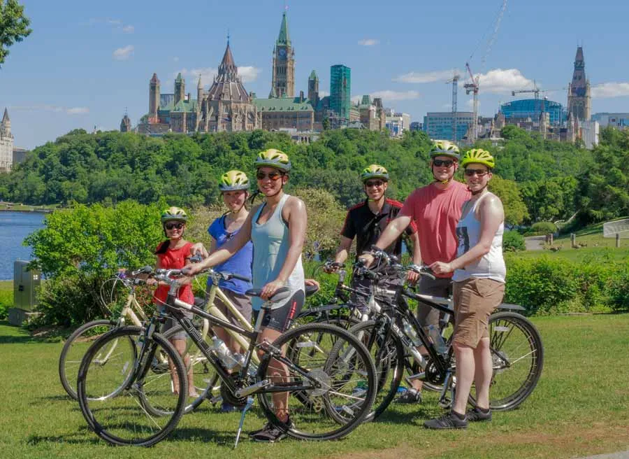 A corporate group taking a private Ottawa express bike tour and stop at Ottawa River path to see the view of the parliament