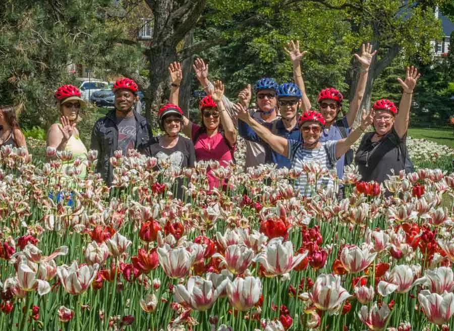 Happy participants are waving hands at Tulip festival at Dow’s Lake during Escape Ottawa Tulip bike tour in May