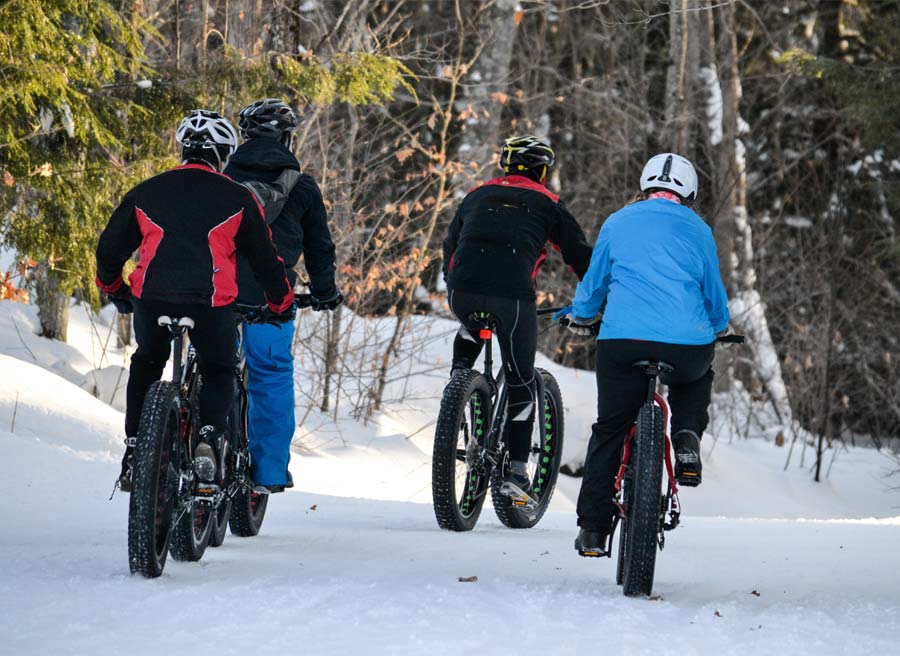 A group is enjoying riding fat bikes during a winter fat bike tour by Escape tours and rentals in Ottawa