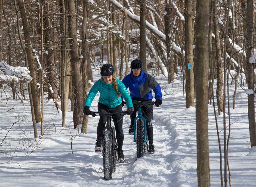 Couples are fat biking in bike trails in Winter in Ottawa