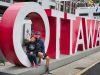 Couple taking a picture next to the Ottawa sign at the Byward market during multi-day bike tour of Ottawa with Escape