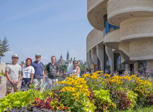 group taking Escape Ottawa Bike Tour and stop at Canadian Museum of History to take a picture
