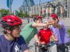 Happy family is taking a selfie in front of Maman, spider at National Art Gallery during express tour by bike in Ottawa