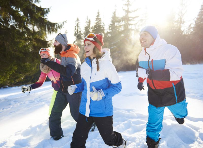 A group of friends are playing and runing in the snow in Winter in Ottawa